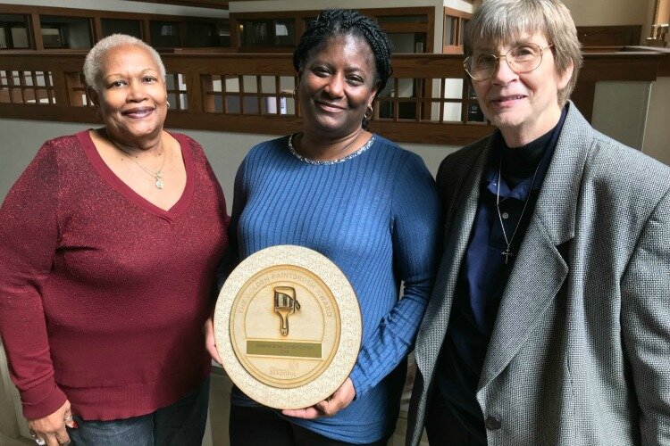 Midge Jackson, Pamela Woods, and Sister Barbara Busch holding a community organizing award that they won.