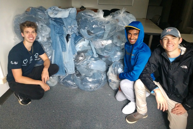 Erek, Siddath Marapane, and Maddox Linneman with the total amount of jeans collected that day.