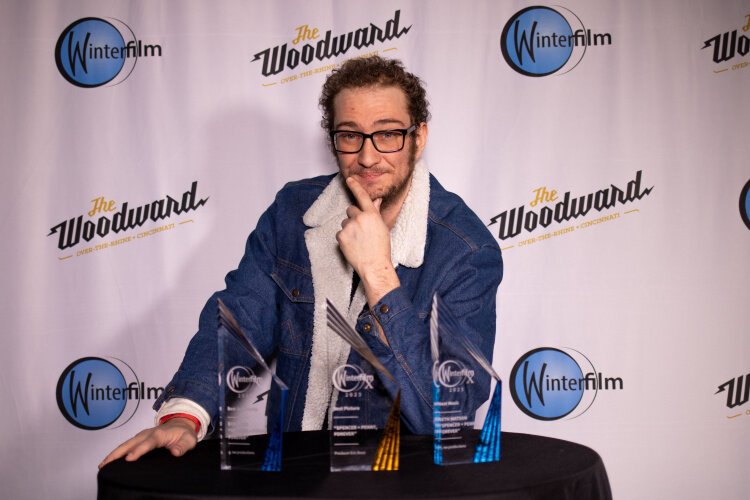 Winterfilm 2023 winner Eric Boso who made "Spencer + Penny, Forever," with his three awards: best picture, screenplay, and music.