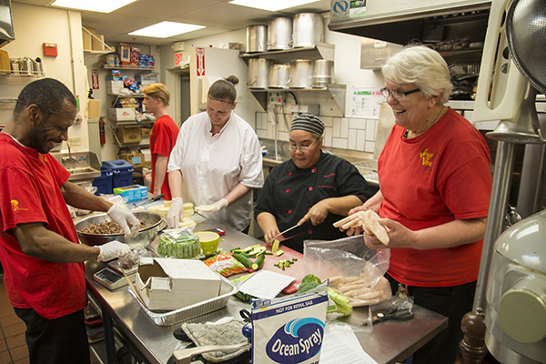 Sister Judy Tensing (right) works with staff and trainees in the Venice on Vine kitchen