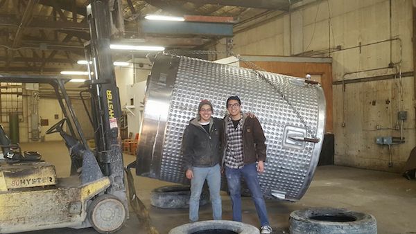 Paul and Josh Kemp stand in front of the first tank at their family's brewery.
