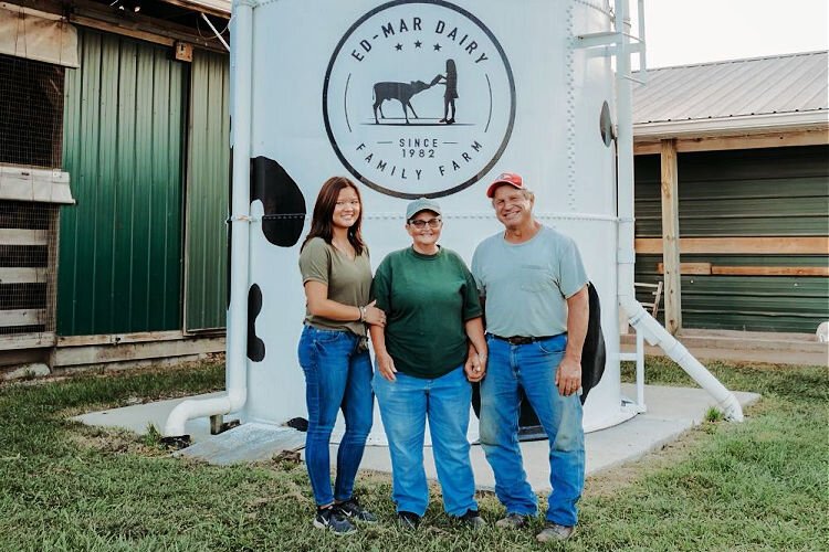 The Gibson family – Ed, Marcy, and daughter Maddie – pose at their farm, which has operated in Walton for generations.