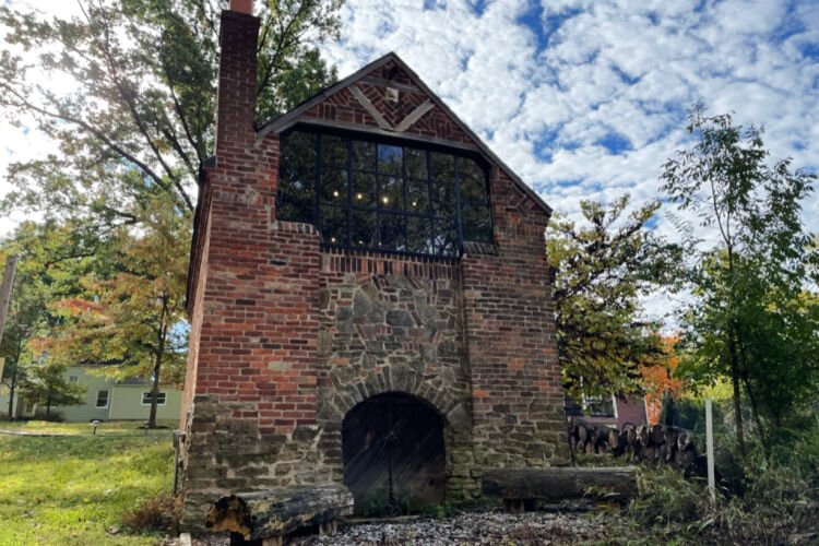 The view of Harlan Hubbard House from the back where you can see the arched door and window.