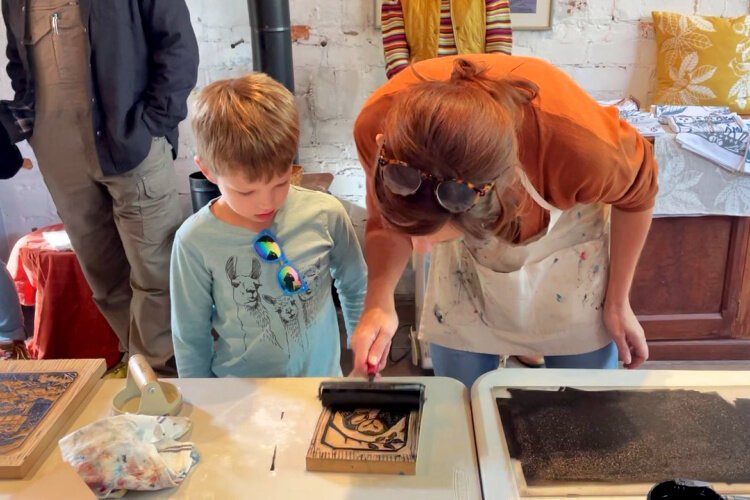 Artist Elizabeth Ross shows seven-year-old Ft. Thomas resident Blaine Bozsan the basics of printmaking.