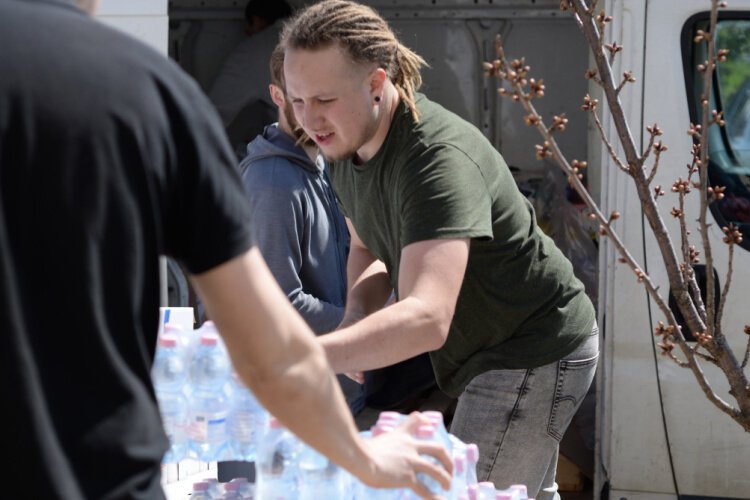 Three to four tons of medical supplies are delivered by Devin Grome, right, and volunteers. The shipment included tourniquets and body bags.