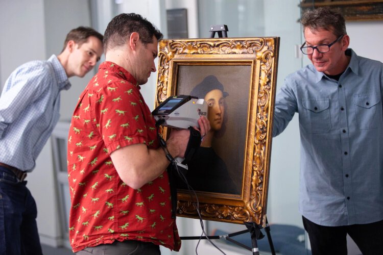 University of Cincinnati geologist Daniel Sturmer uses XRF spectroscopy to study the pigments in a painting from UC's art collection during a demonstration. Also pictured l to r: Christoper Platts and Aaron Cowan