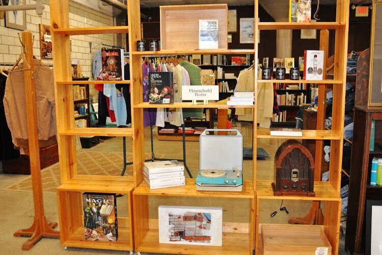 A shelf of “Household Items” includes nostalgic objects such as an old record player. Behind the display case is the section of carefully curated vintage clothing.