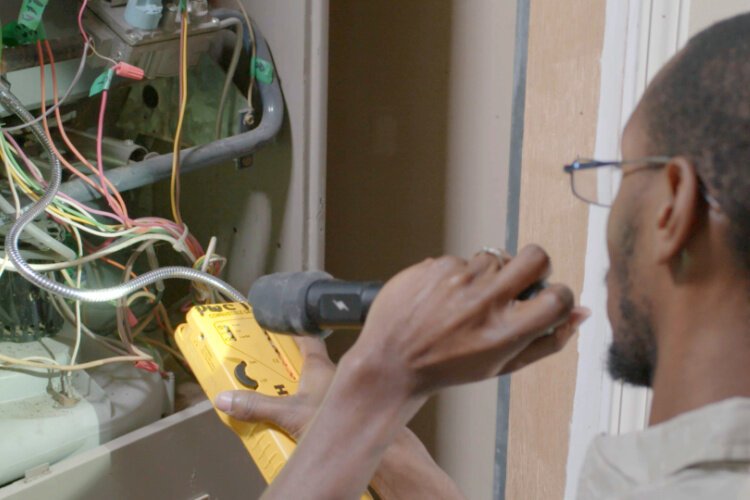 PWC technician diagnosing a furnace repair.