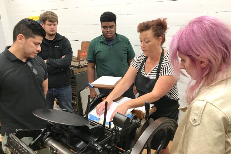 Trainer Jen Penley with a group during the Inner City Project. All four are now working in the print industry.