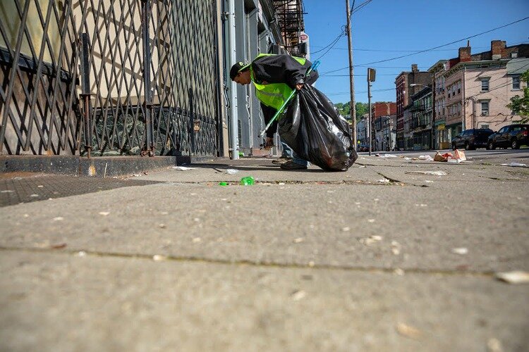 The benefits are twofold: People in need get work and trash gets removed from downtown streets.