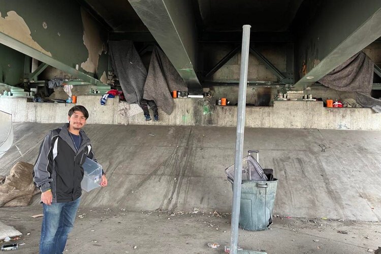 Matthew Kamradt of Loaves and Fishes checks out an area on Gest Street for unsheltered people who need food or clothing.