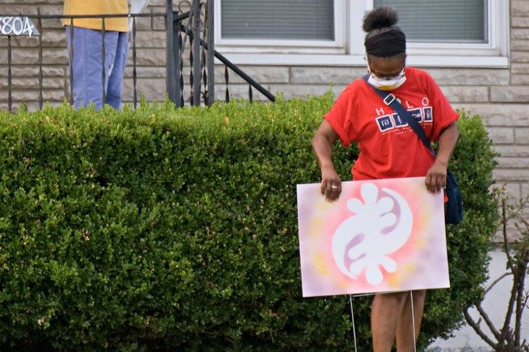 Volunteers will distribute screen-printed masks, kits with beads and lanyards for stringing, and yard signs with African Adinkra symbols for residents to decorate and display in their yard. 