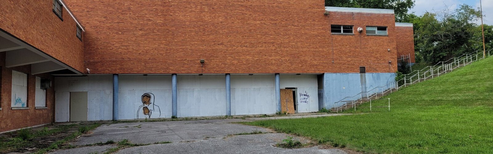 The old Schroder High School location in Kennedy Heights is rife with broken windows door, and graffiti. Pictured: "I howdy, come inside."  