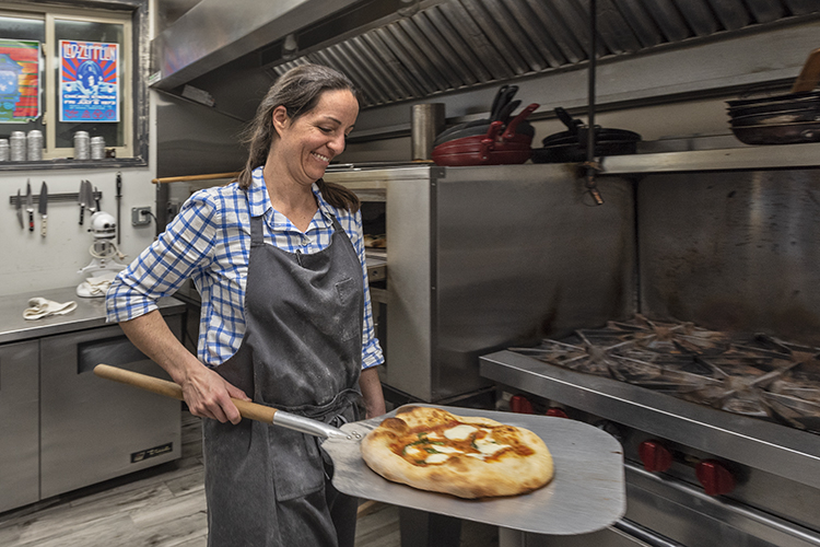 Each pizza is cooked in a stone oven.