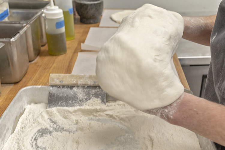 She then tosses the pies by hand.