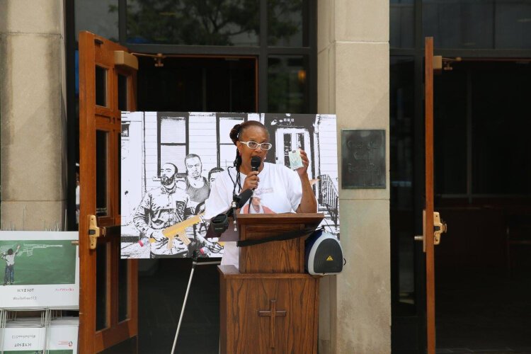 Hope Dudley, Founder of UCanSpeakForMe, lost her son to gun violence in 2007. Dudley shows the gathering a pack of cards with pictures of victims of unsolved homicides. The cards are distributed to area prisons.