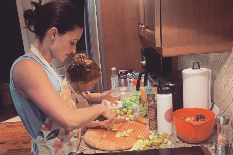 Krista and her daughter cooking a healthy meal.