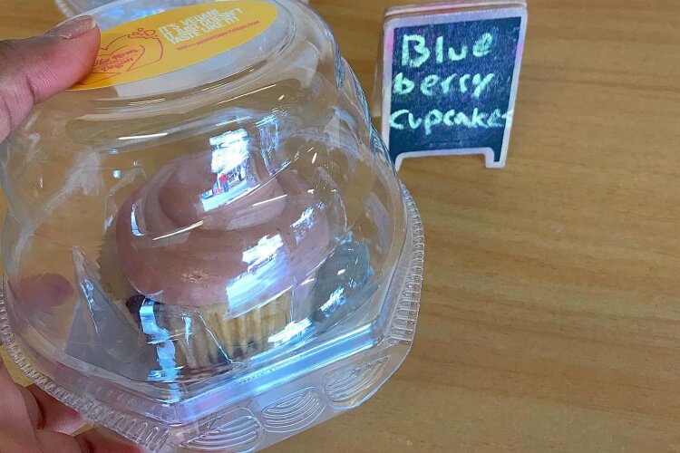 A vegan blueberry cupcake with strawberry frosting.
