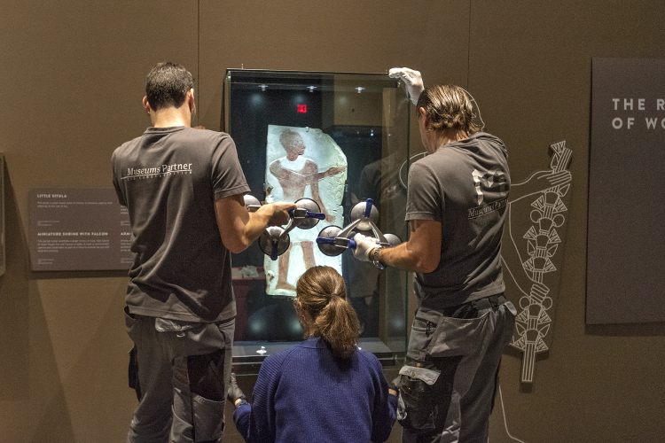 Curators carefully uncrate each artifact.