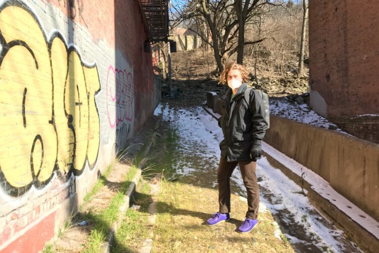 The alley is littered with garbage, and for most of its length, someone walking there needs to navigate ruts, broken asphalt, and rocks.