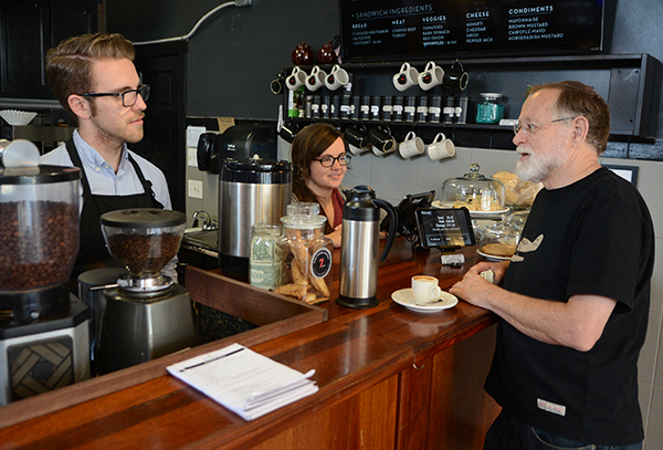 Larry Bourgeois (right) talks with baristas at BLOC Coffee Company in Price Hill