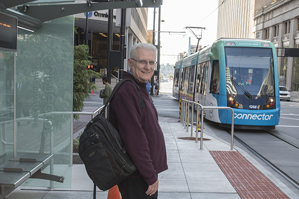 John Schneider ready to board the streetcar after picking up a gallon of milk from the store.