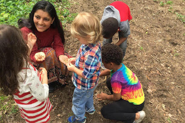 Heärt Montessori co-founder Nayana Shah shows children a handful of seeds while exploring the outdoors.
