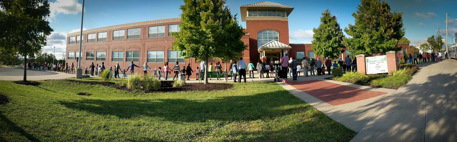 Pleasant Ridge Montessori families and faculty members at Hands Around the School celebrating the building's ten year anniversary.