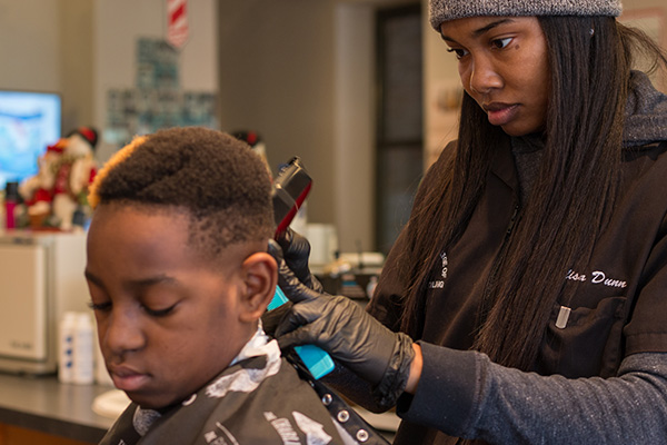 Jay Dunn, barber at DJ's, cuts Lamarion Bush's hair.