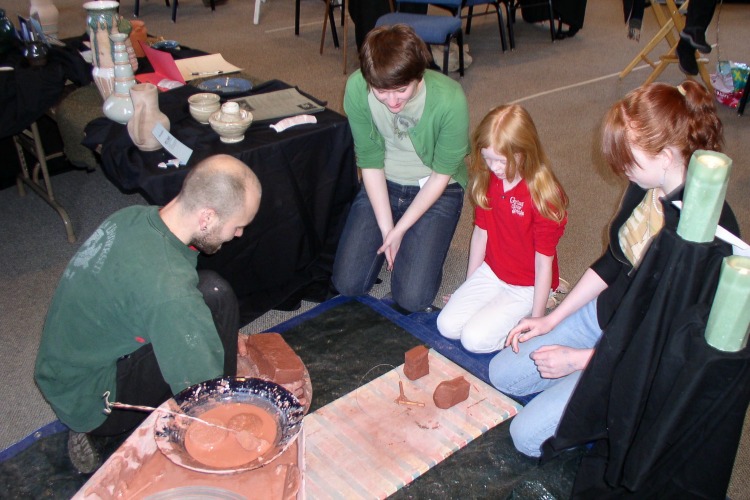 Eric Hauck, the originator of the fair, teaches kids how to throw a pot. 