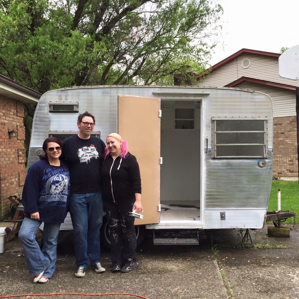 Janet Creekmore, Ben Jason Nel and Melissa Mitchell with their vintage camping trailer before it became a mobile art gallery.