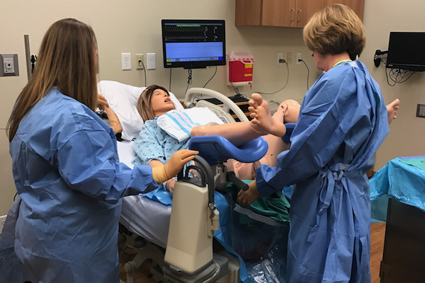 St. Elizabeth Education Specialists Chris Rust (left) and Tabatha Biddle demonstrate the "SimMom" mannequin used in labor & delivery training