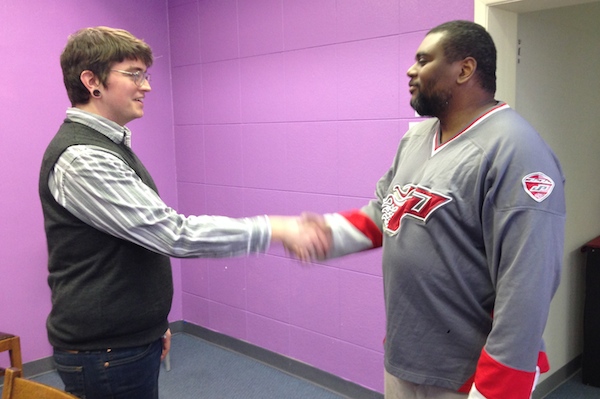 Melodic Connections staffer Bill Brock (left) speaks with Joseph, who's volunteering at the Symphony