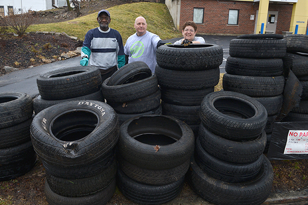 Patti Hogan hauls old tires with Bob Greenlee (left) and John Ridder