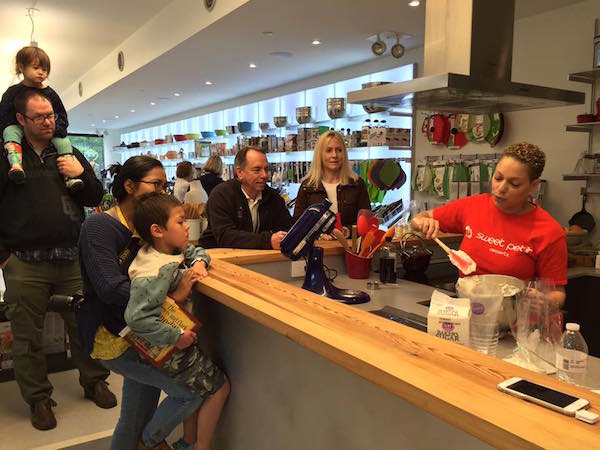 Artichoke customers watch the owner of Sweet Petit Desserts demo how to make macarons