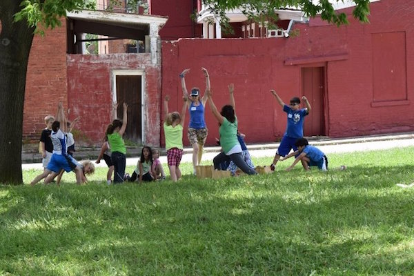 A group of children do yoga as part of Annie Brown's Healthy Mind & Body Day Camp, which was held at the end of the school year.