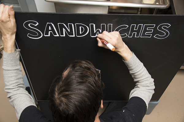An employee prepares a sign in preparation for this weekend's grand opening.