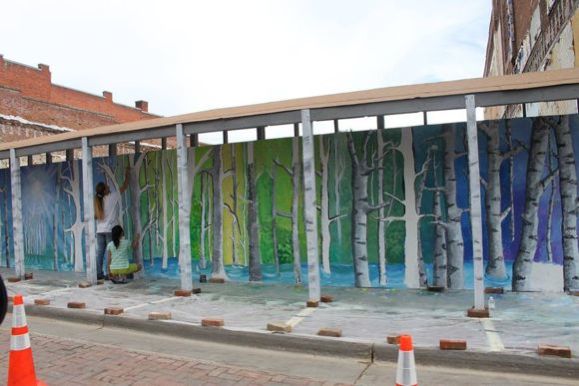 Artists work on a treescape in Trinidad, Colo.