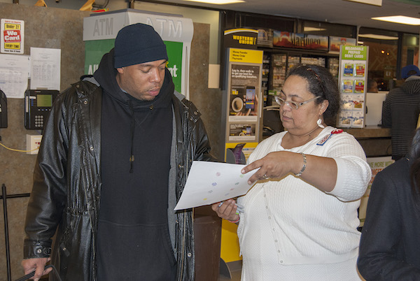 Walnut Hills resident and community leader Kathryne Gardette discusses food-sourcing options with Kroger shoppers.