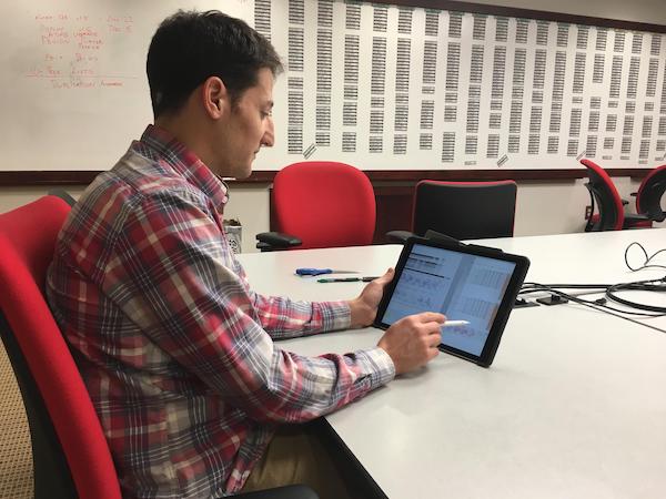 Reds' Assistant GM Sam Grossman uses an iPad in pregame strategy.