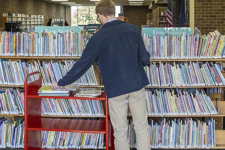 Sam Kovach shelves books at the current Forest Park branch.